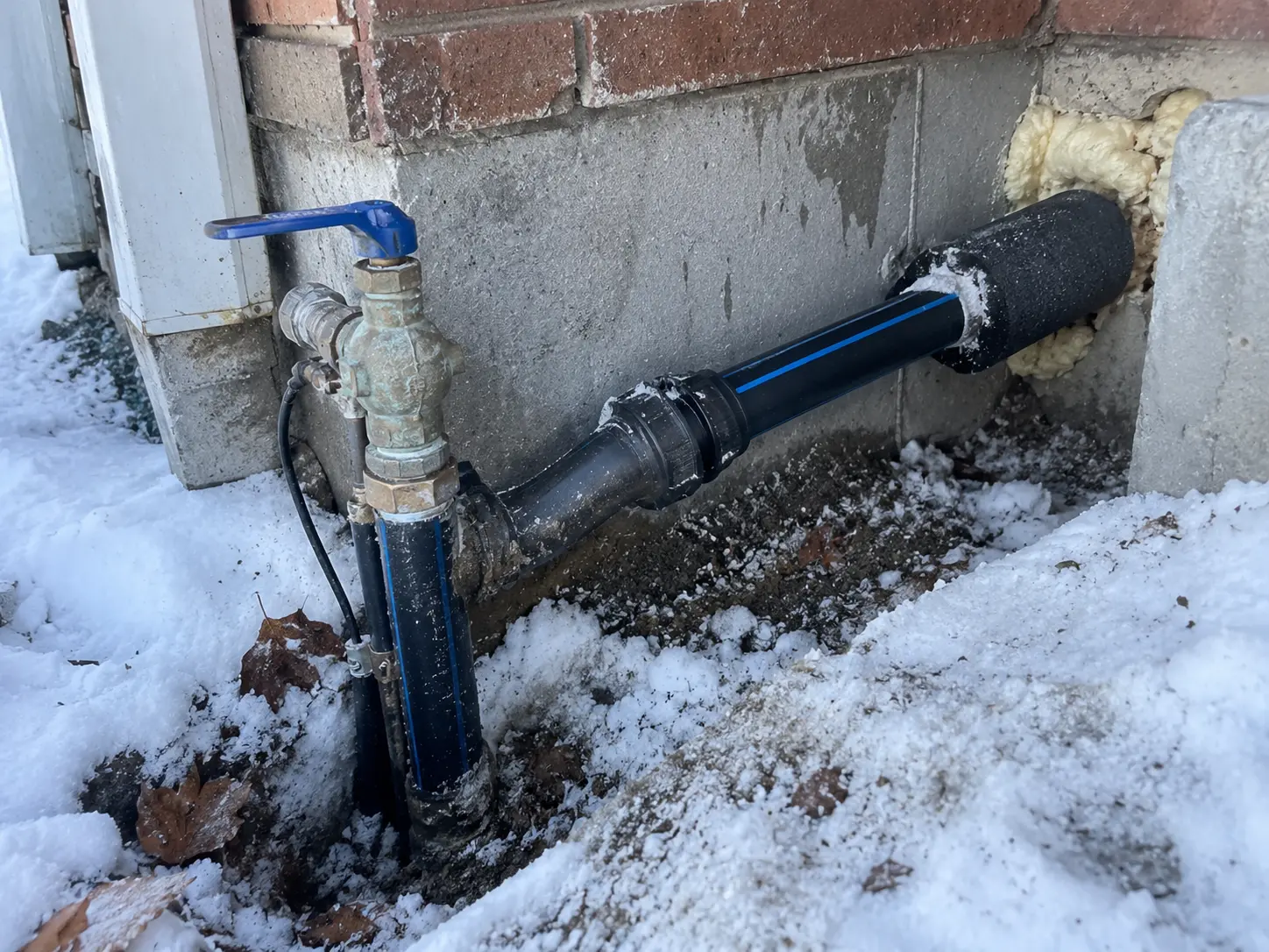 Technician replacing a damaged water supply line under a sink